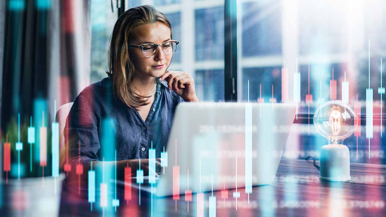 Lady sitting in front of the computer studying how to invest