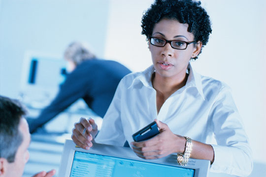 women leaning on a computer